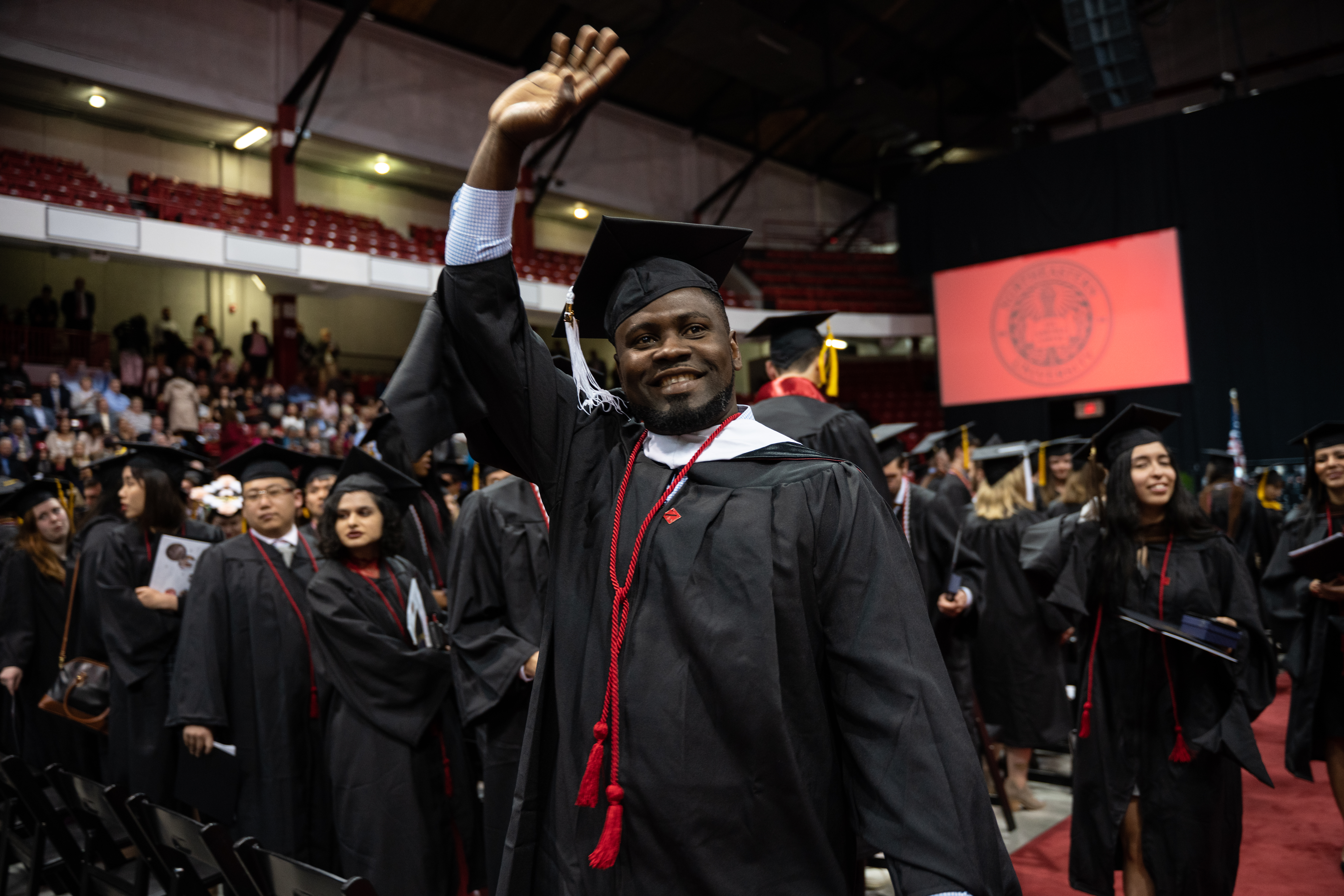 Student waving at graduation ceremony