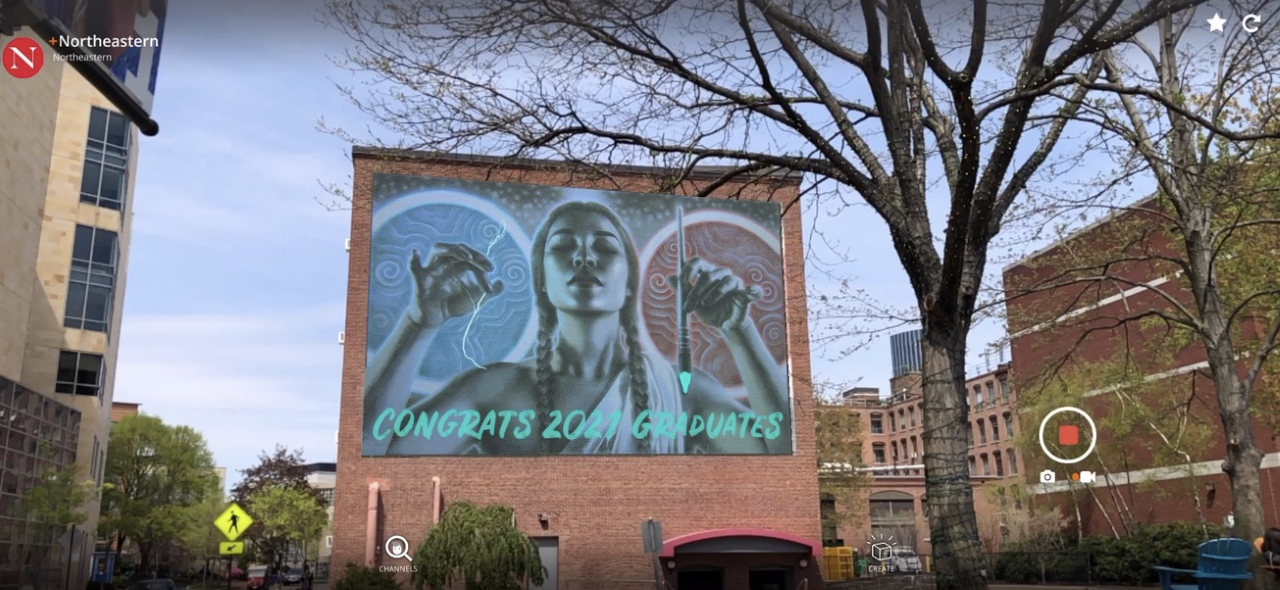 Mural of a Native American woman holding a lighting bolt and paint brush on a brick building.
