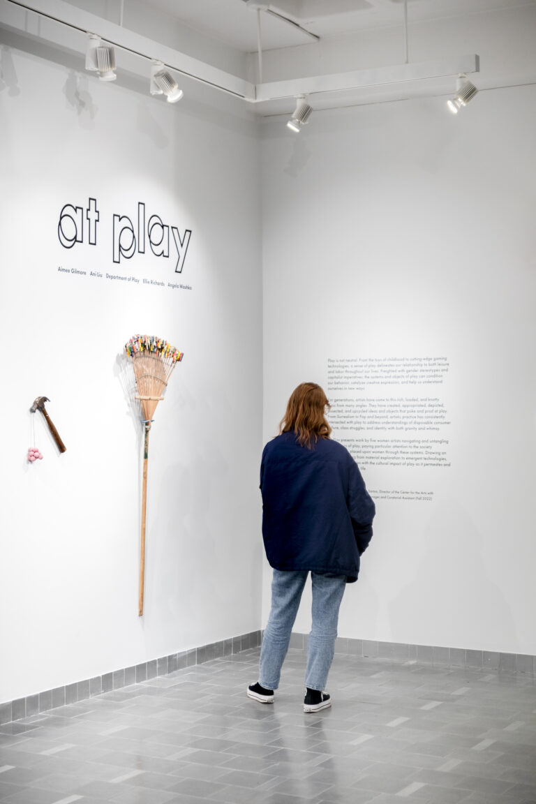 Image shows a gallery attendee reading the wall text at Gallery360's 2023 exhibition "At Play."